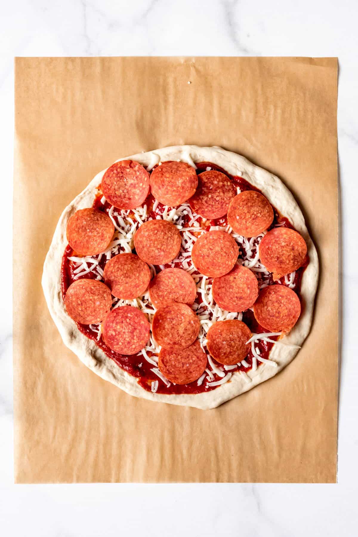 Pepperoni arranged on top of a homemade pizza.