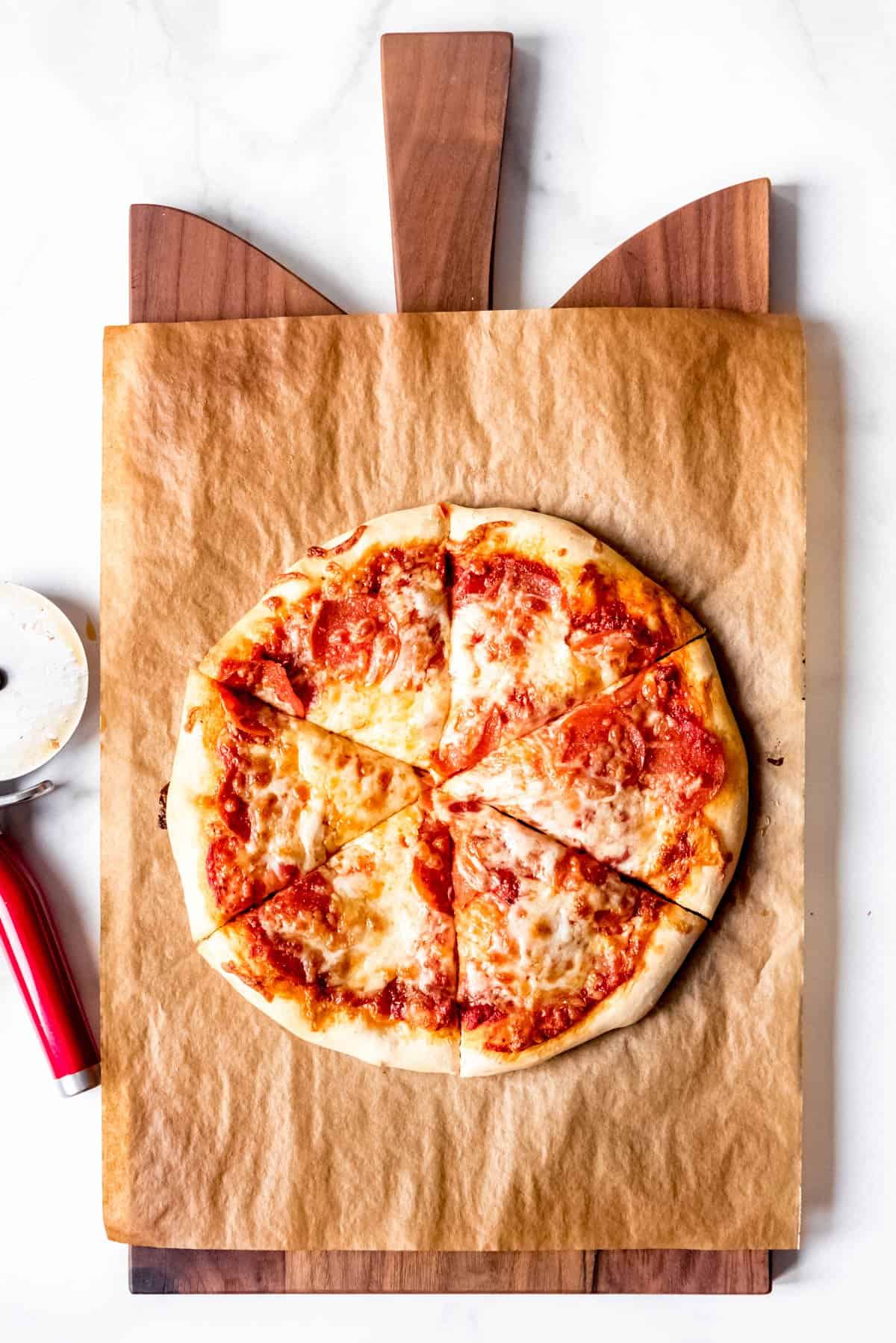 An image of a homemade pepperoni pizza on a cutting board.