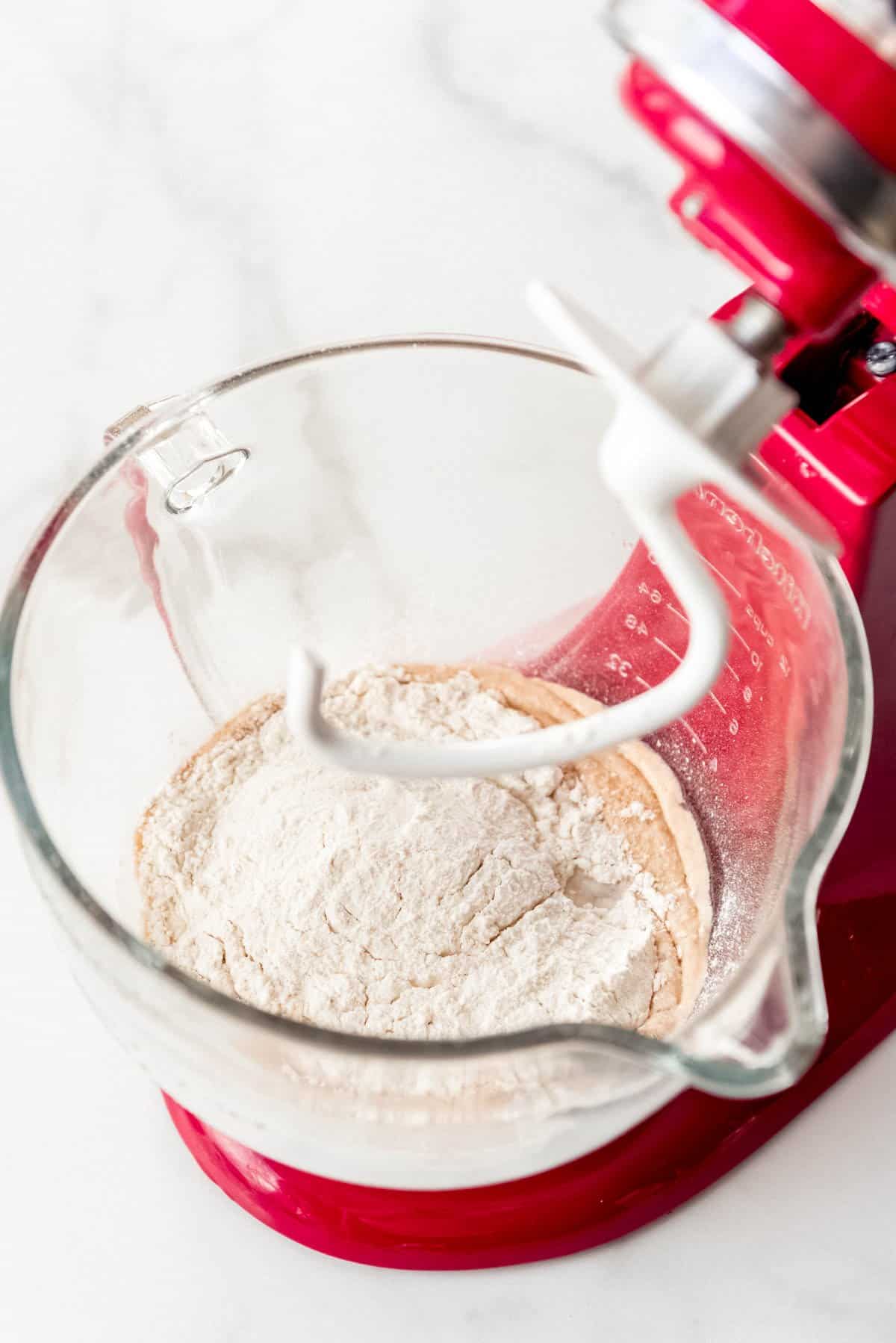 Adding flour to proofed yeast in a Kitchenaid mixer.