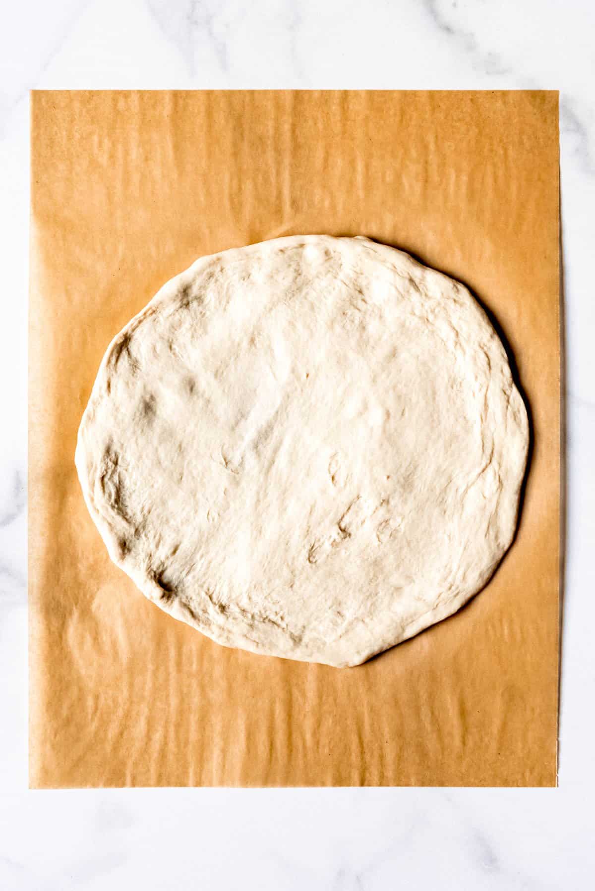 An image of a circle of unbaked pizza dough.