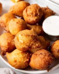 An image of deep fried balls of cornmeal dough known as hush puppies in the South.