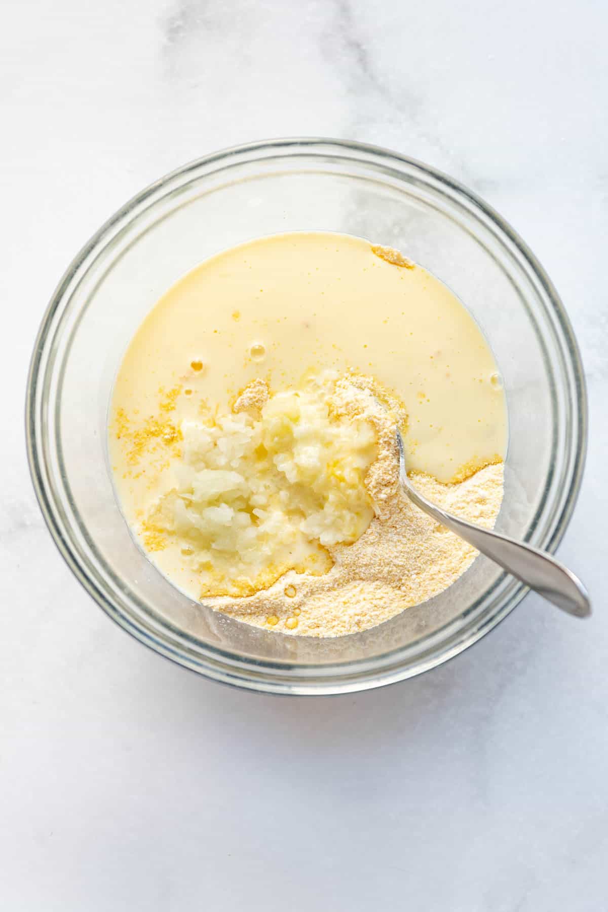 Adding wet ingredients to dry ingredients in a bowl.