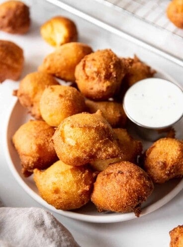 An image of deep fried balls of cornmeal dough known as hush puppies in the South.