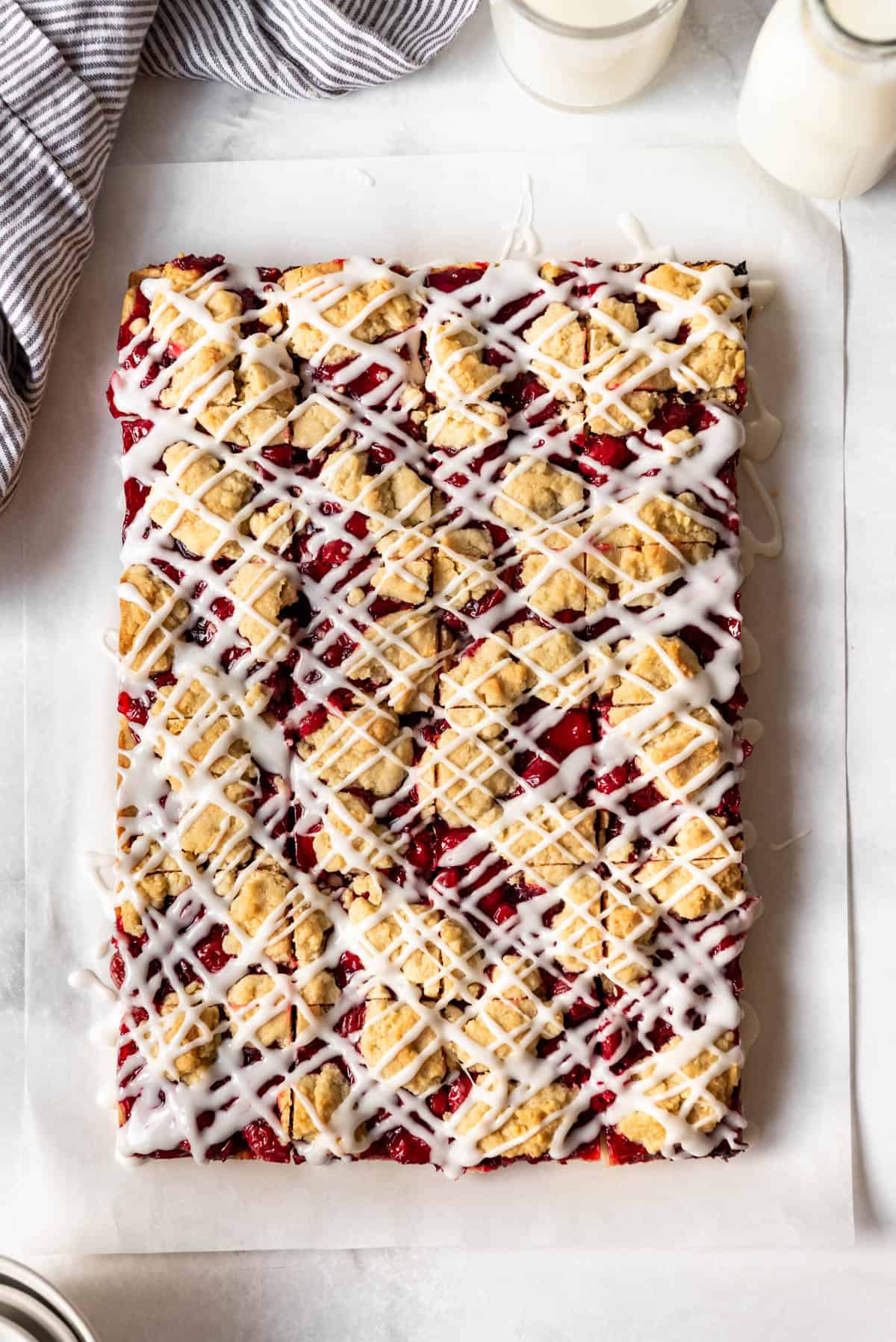 Adding zigzags of a simple glaze over cherry pie bars.