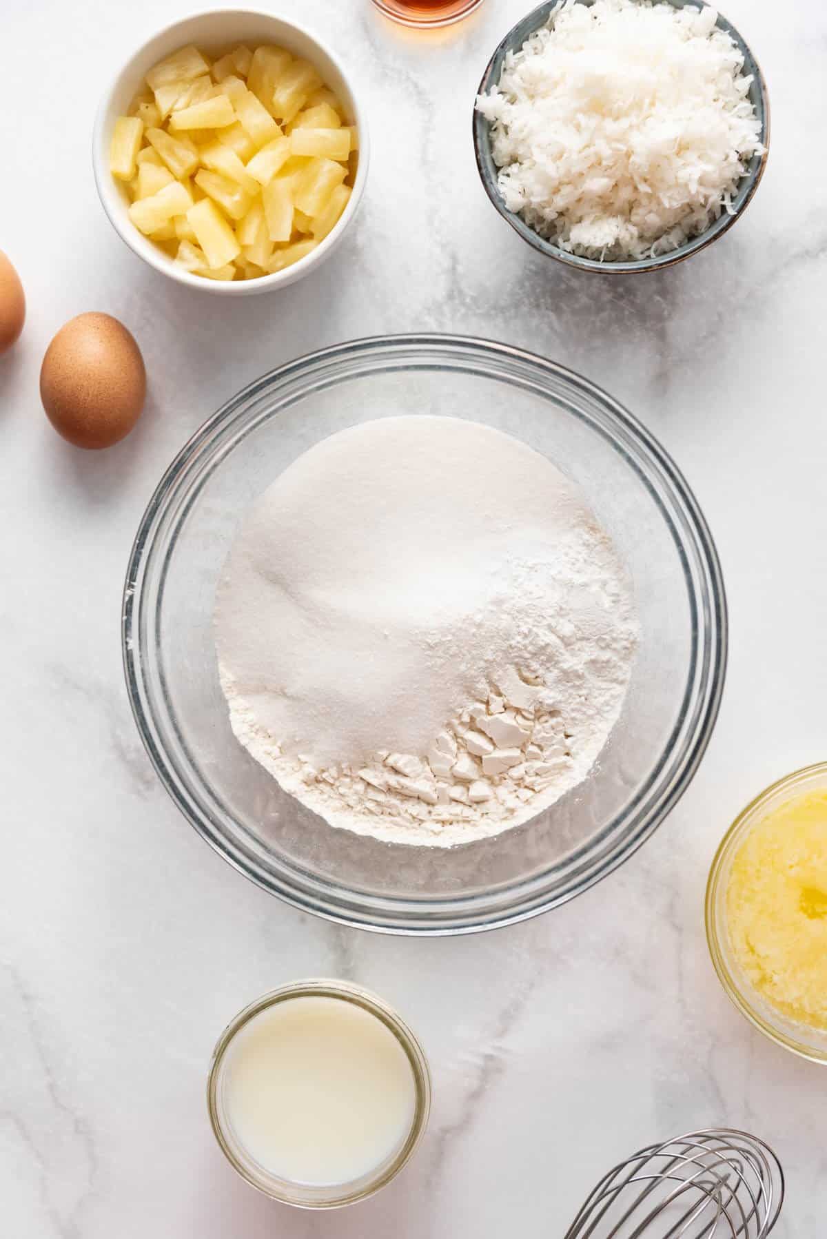 Sugar, flour, baking powder, and salt in a glass bowl.