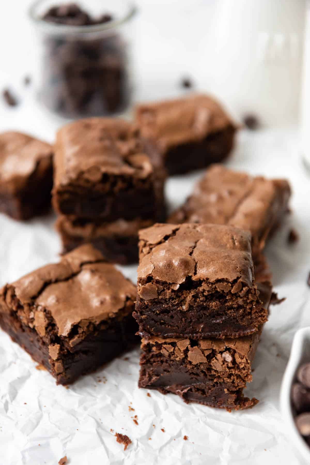 Homemade brownie squares made in a small batch arranged on white parchment paper.