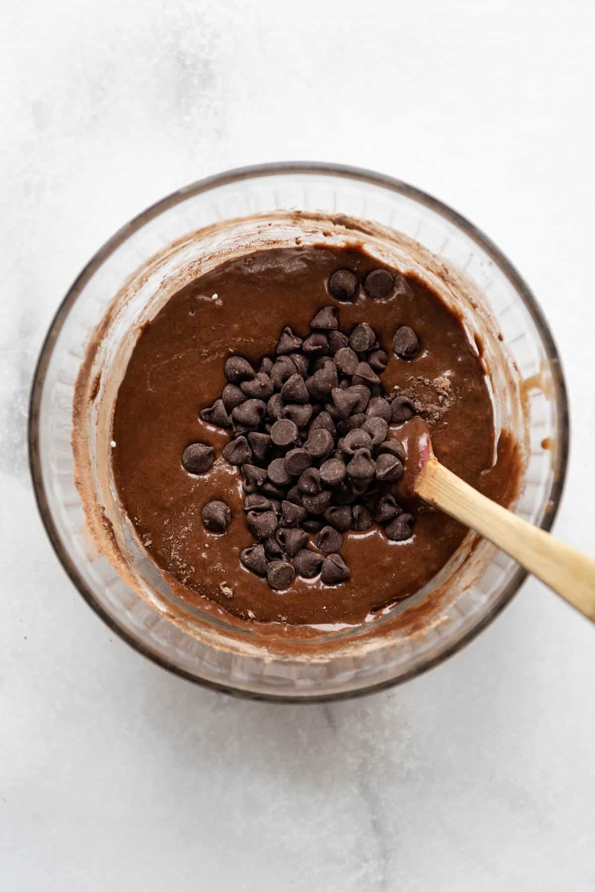 Stirring chocolate chips into brownie batter.