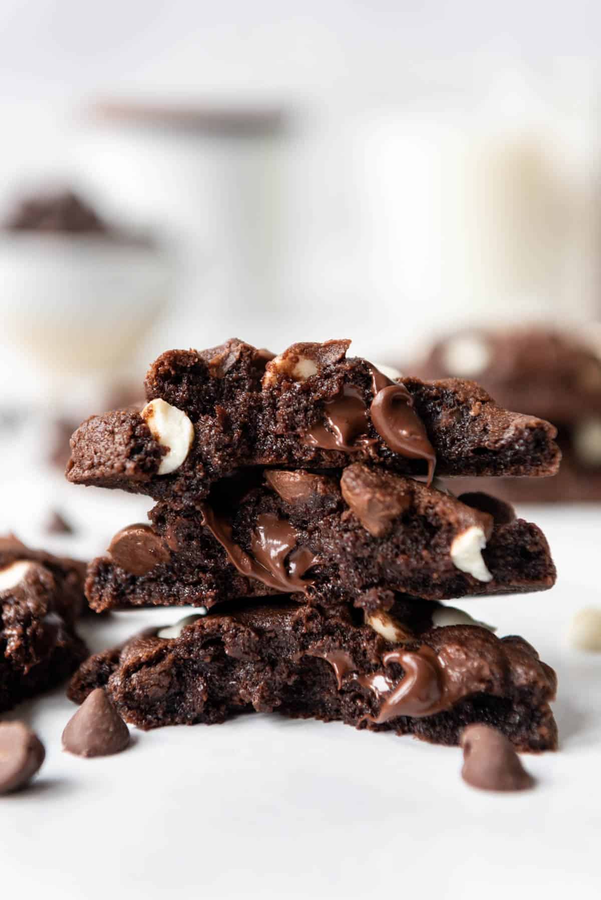 Chocolate cookies broken in half and stacked with melted chocolate chips inside.