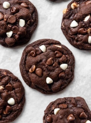 A close image of a chocolate cookie with white and milk chocolate chips.
