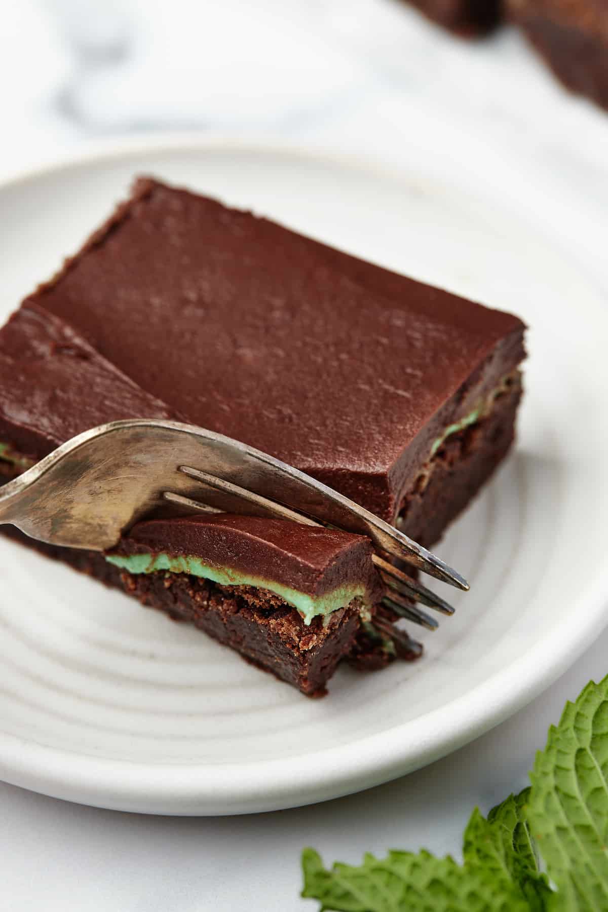 A fork digging into the corner of a frosted mint brownie