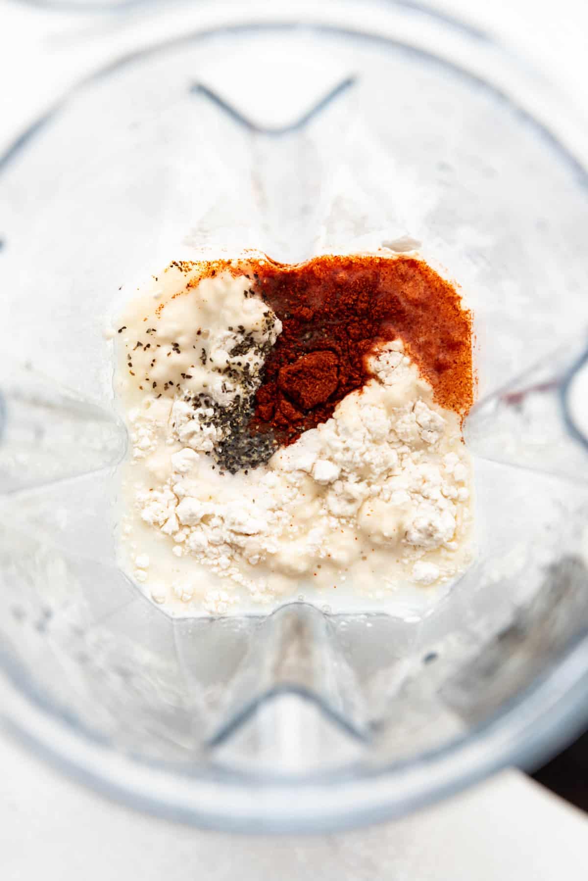 Combining eggs, milk, flour, and spices in a blender.