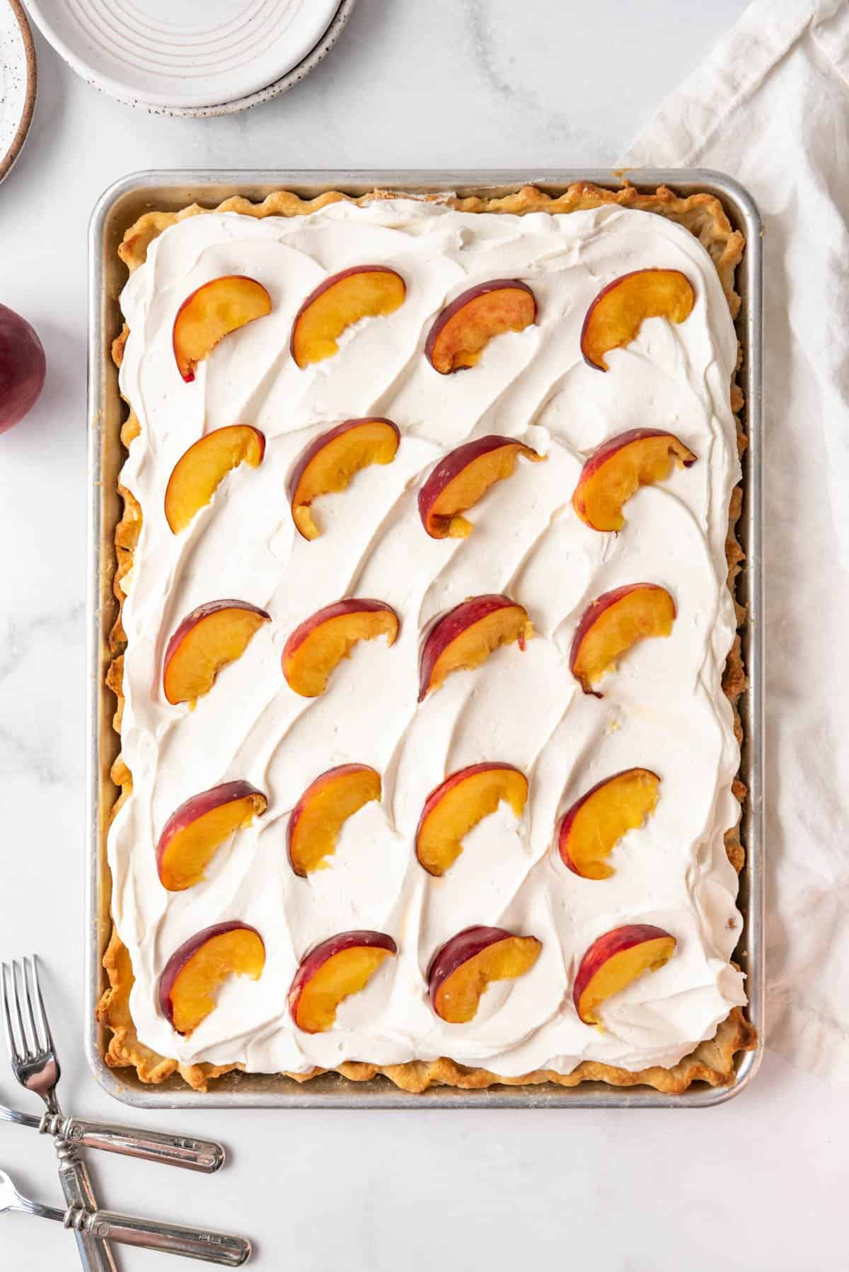 Fresh peach slices decorating the top of a peaches and cream slab pie.