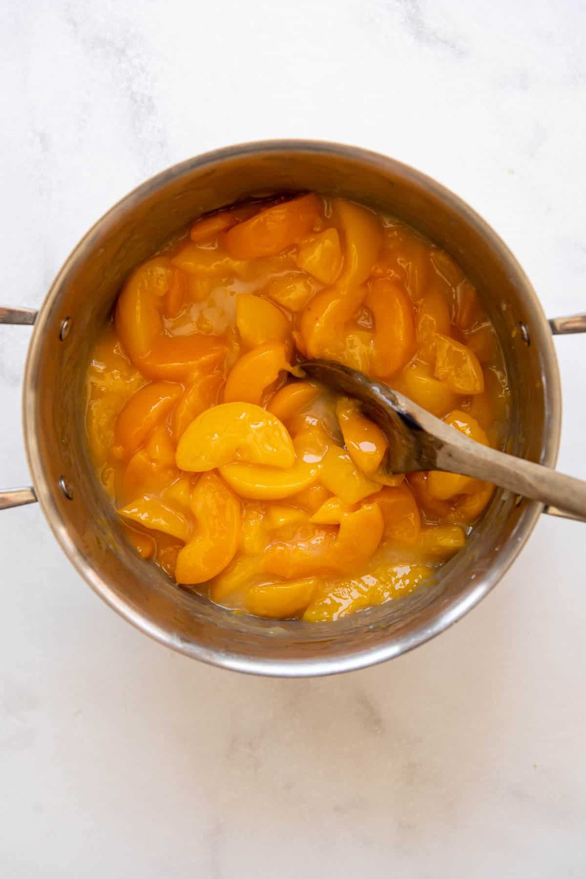 Making peach filling on a large pot.