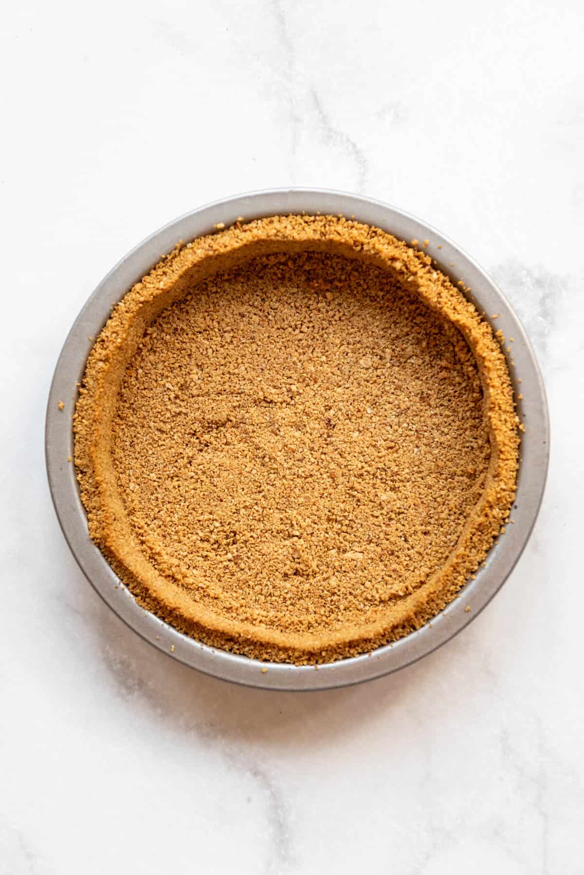 A baked graham cracker and pecan pie crust.