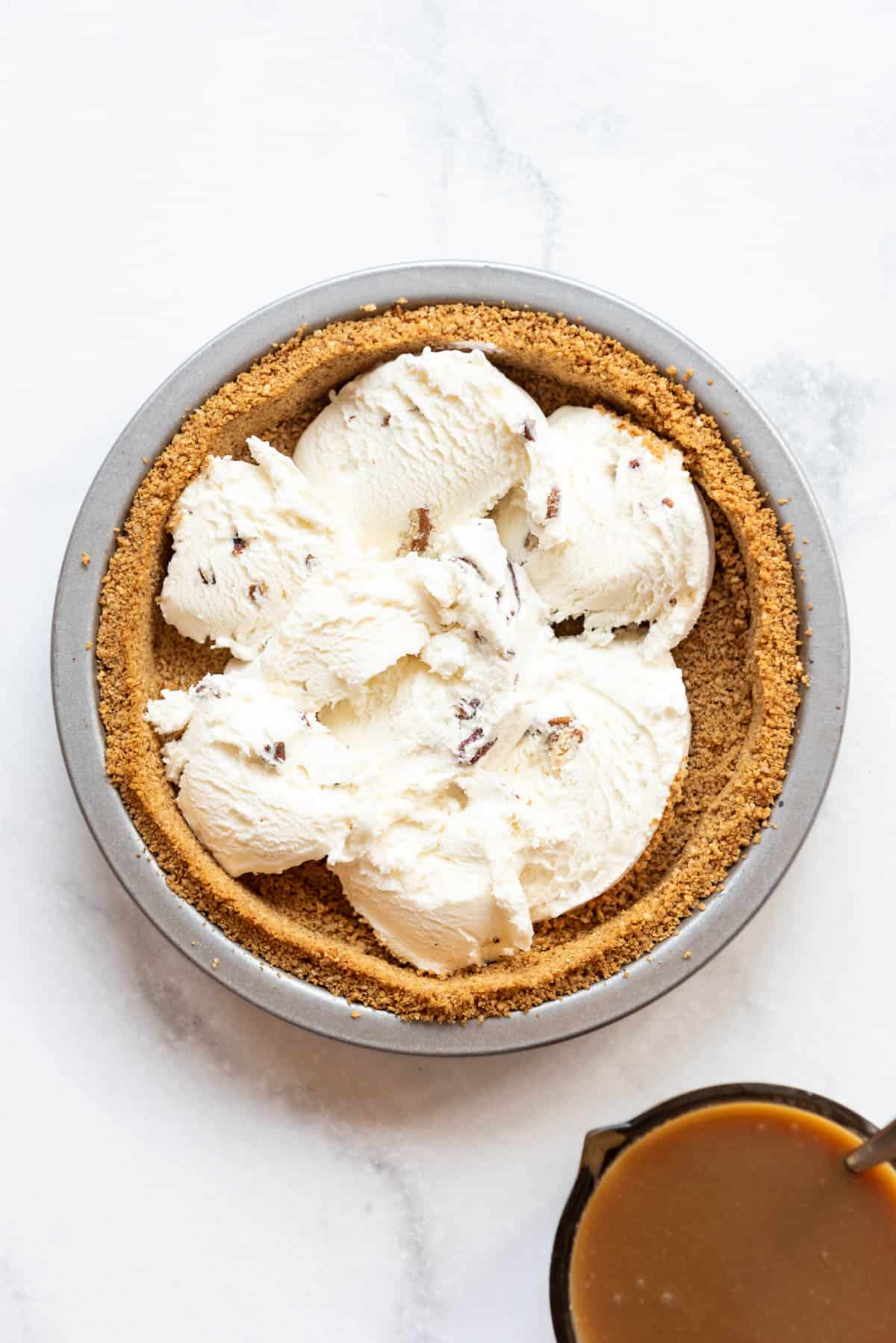 Scoops of softened butter pecan ice cream in a graham cracker crust.