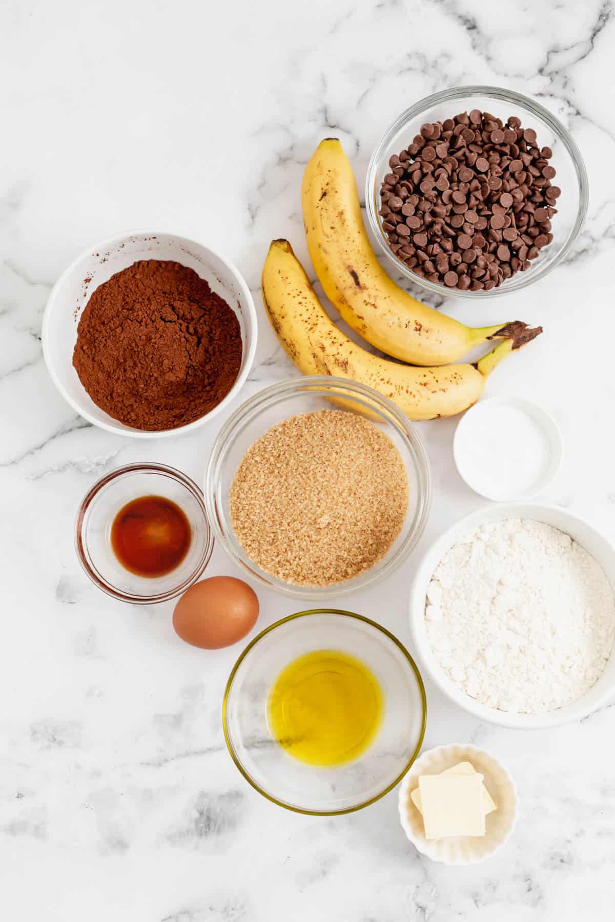 Ingredients for chocolate banana bread in separate bowls.