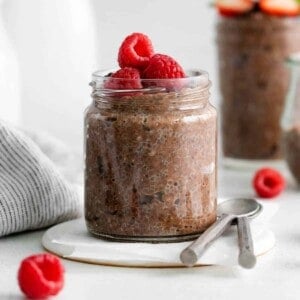 Chocolate chia pudding with raspberries in a glass jar.