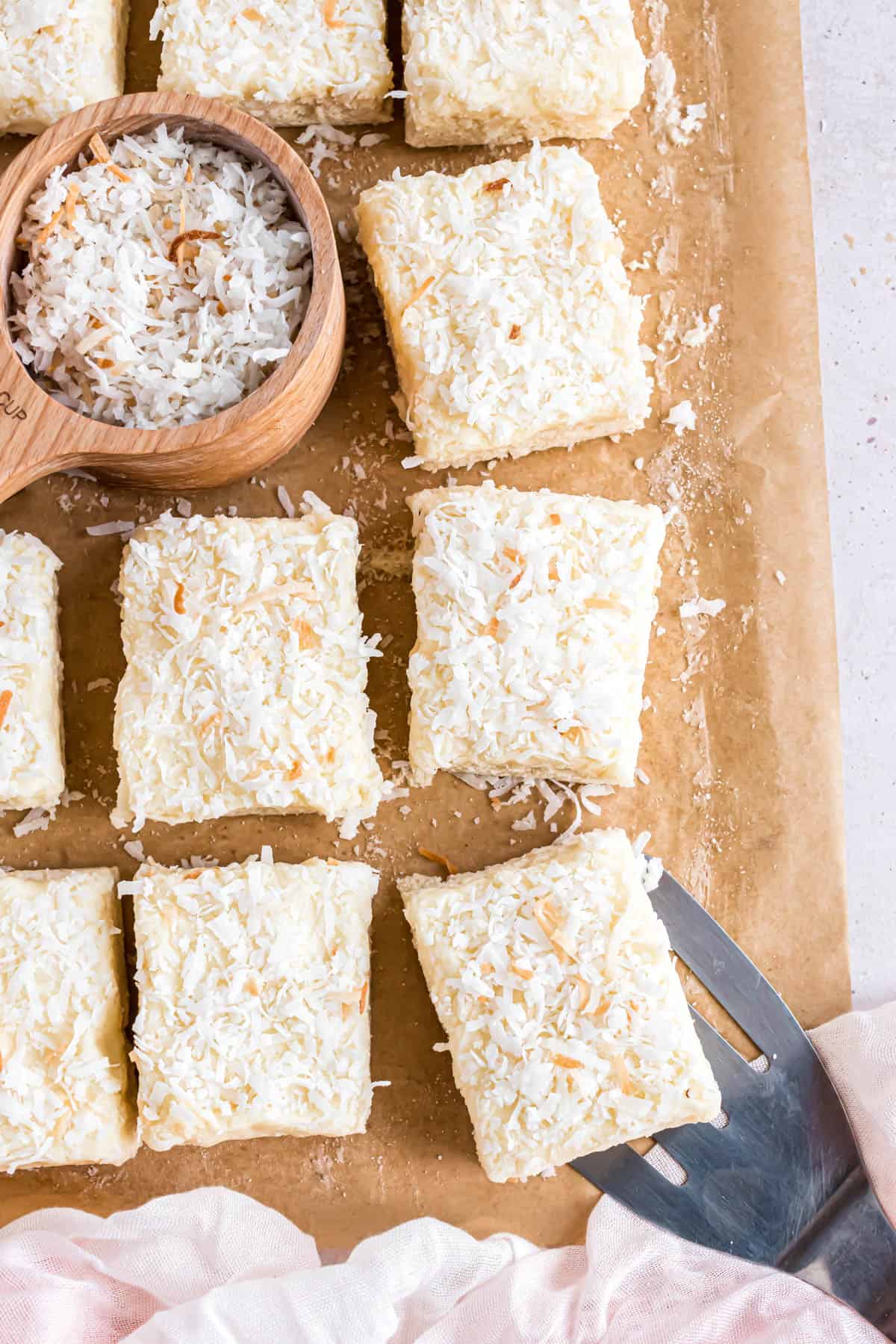 An overhead image of frosted coconut sugar cookie bars cut into squares.