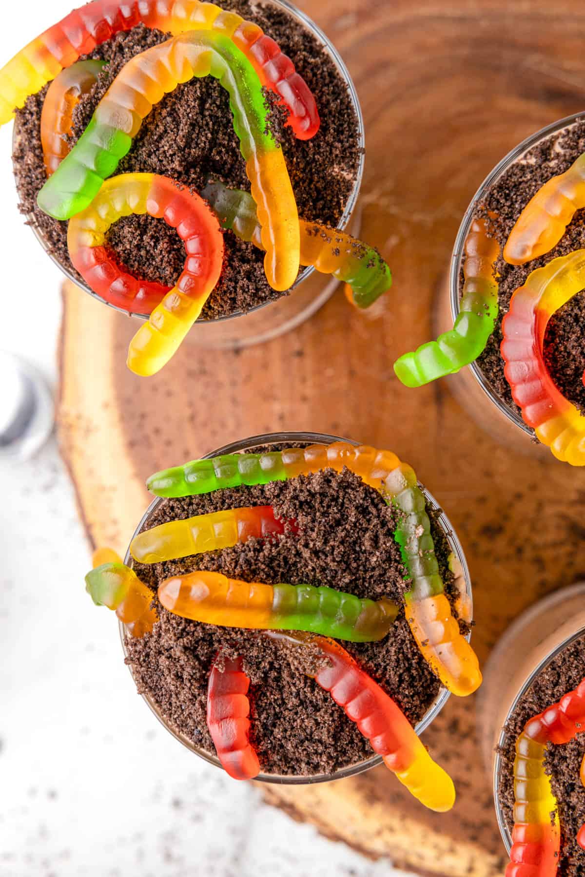 Gummy worms on top of crushed Oreo cookies.