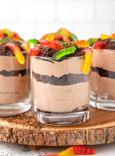 Dessert cups of dirt with gummy worms on top.
