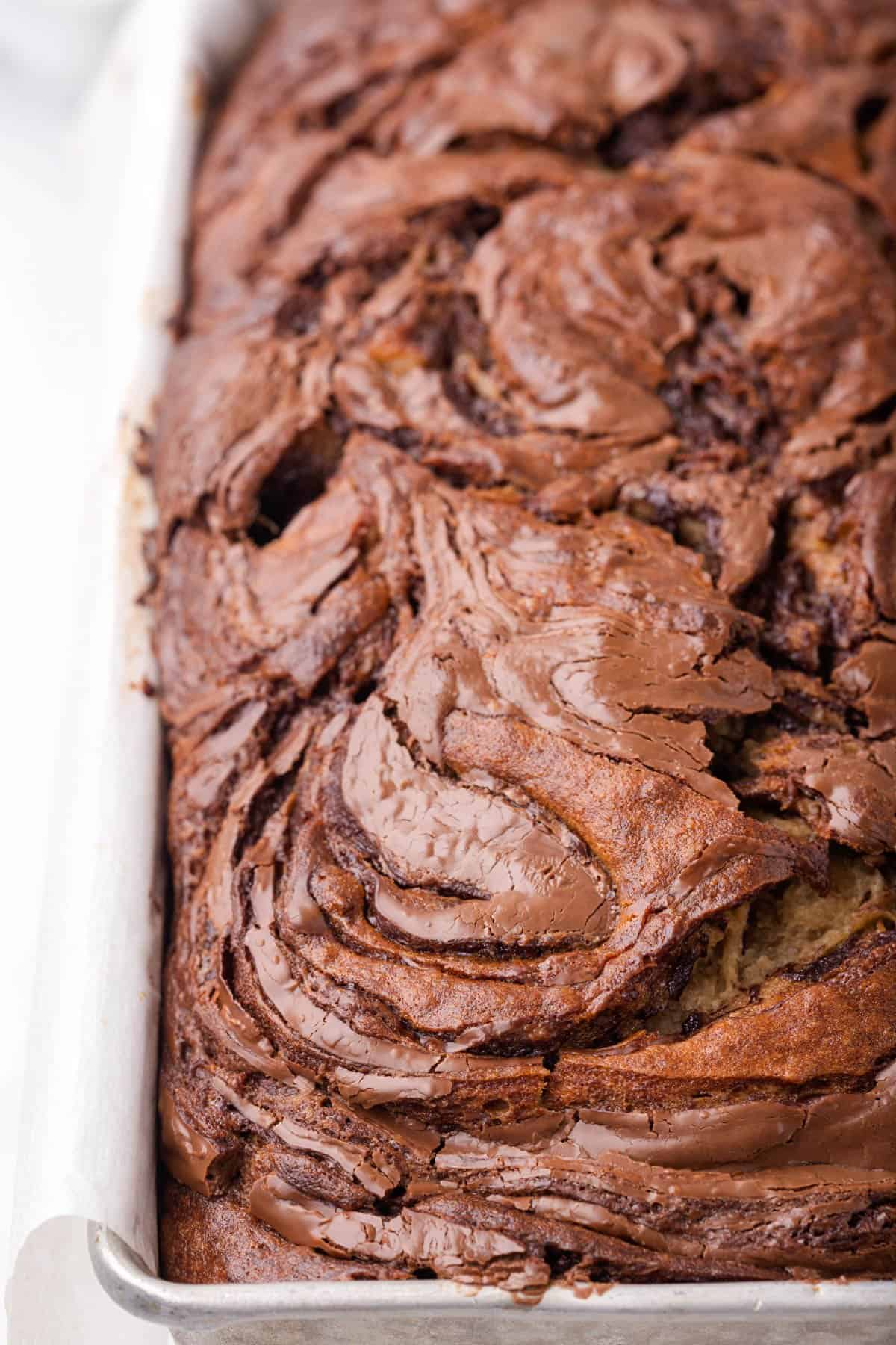 A bread pan filled with Nutella swirl banana bread.