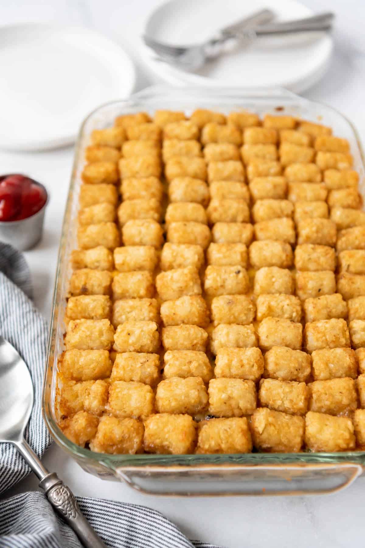 Baked tater tot casserole with the tater tots arranged in rows on top.