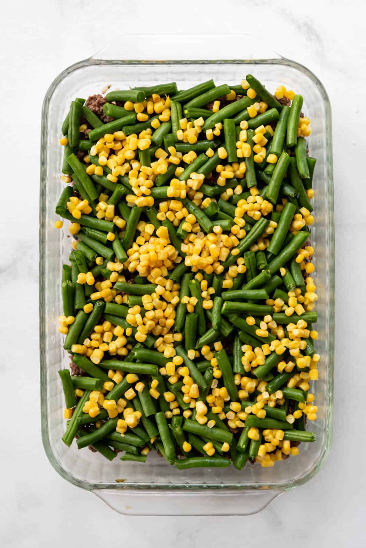 Green beans and corn in a large casserole dish.