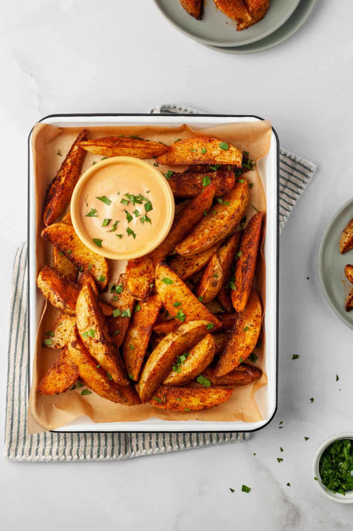 Barbecue potato wedges on tray with bowl of dipping sauce