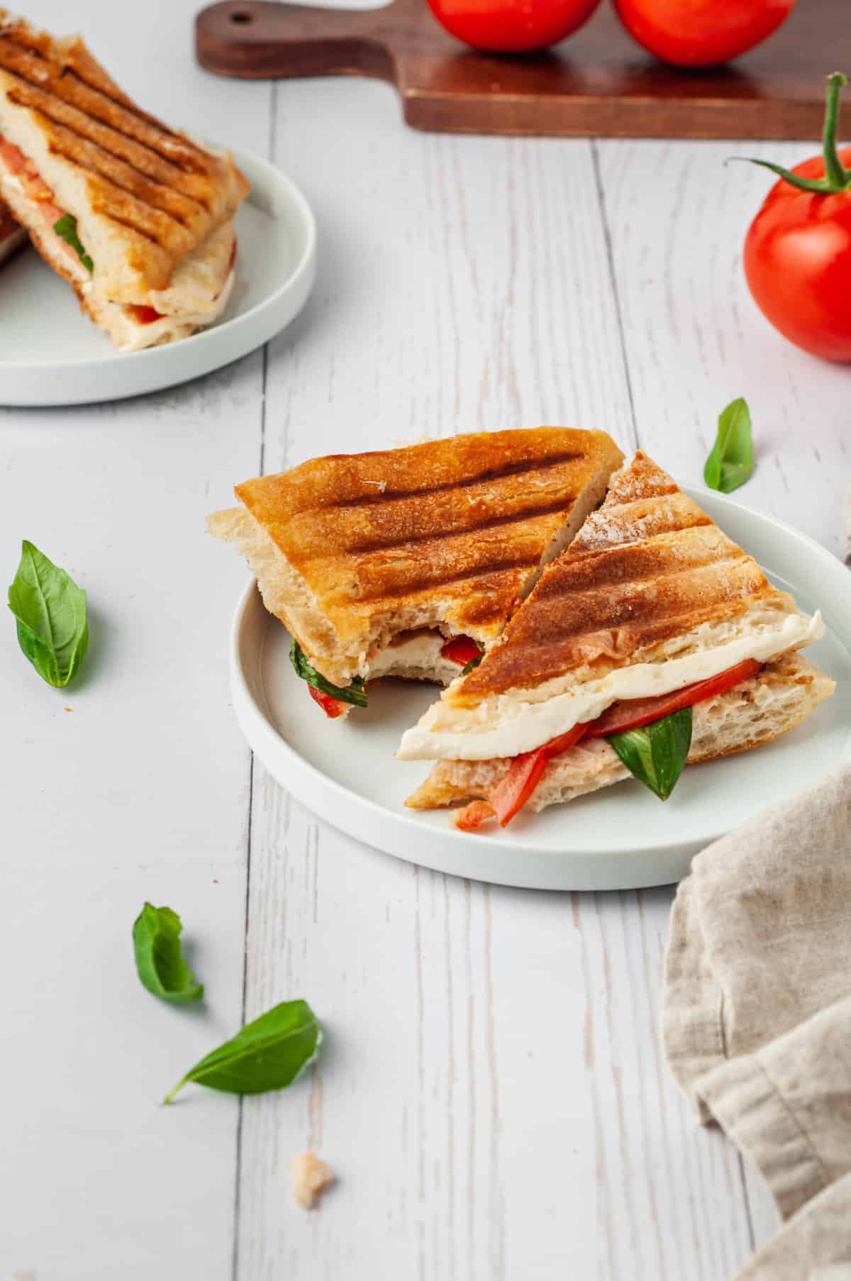 Caprese panini on plate with bite taken out