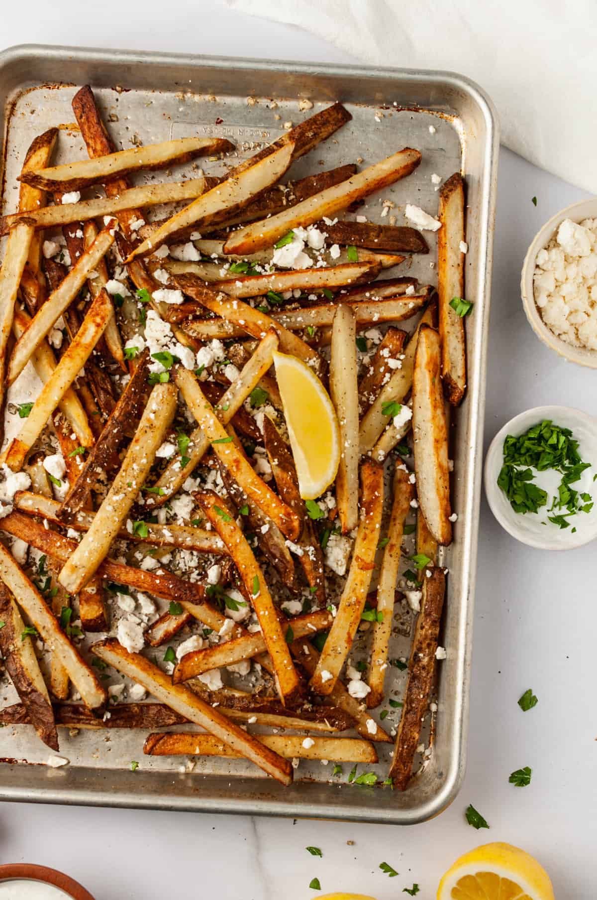 Sheet pan of seasoned Greek fries