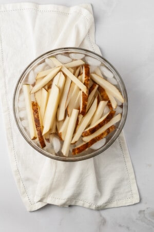 Fries in ice water to soak off starch