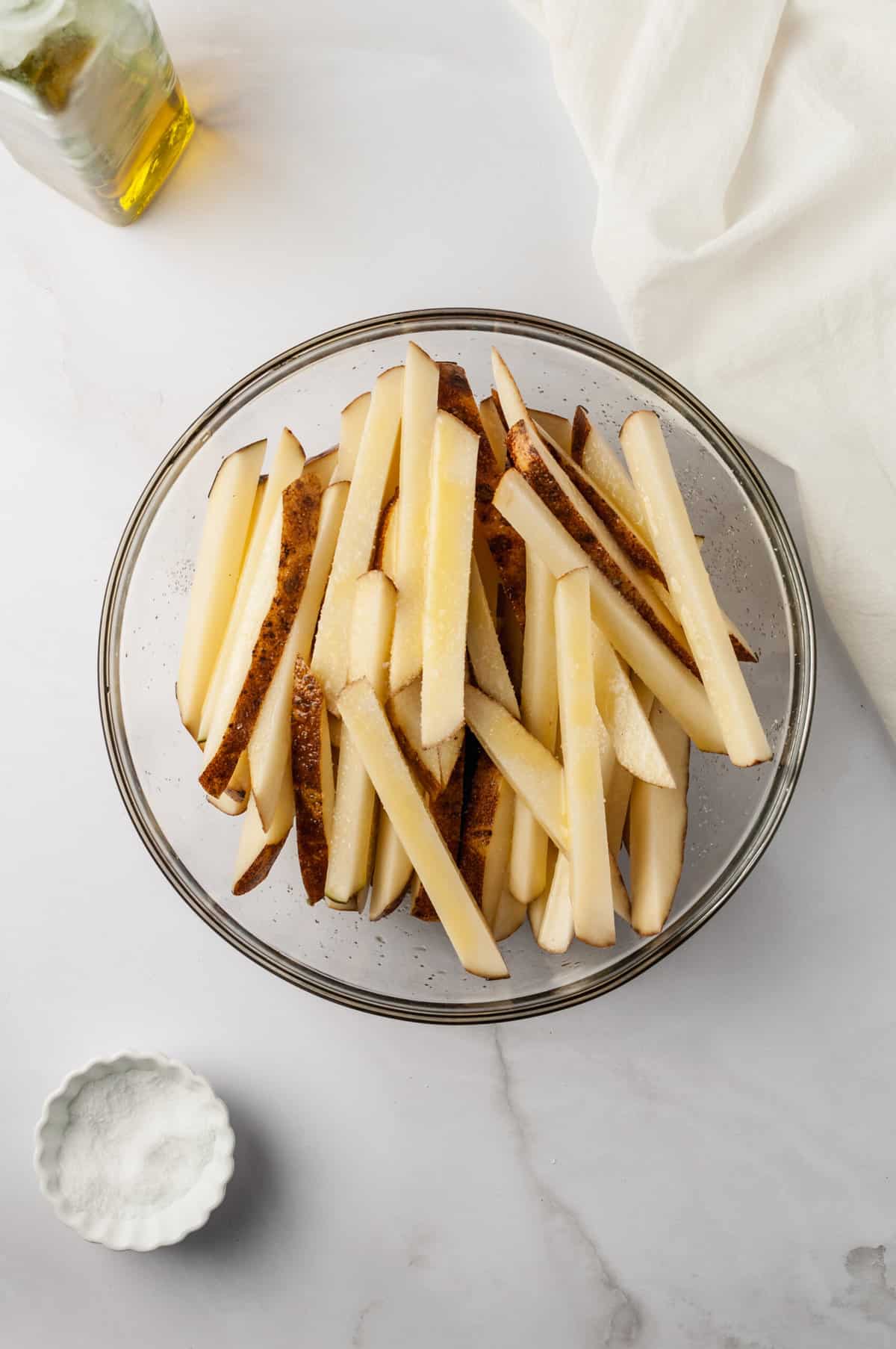 Fries in glass bowl before baking