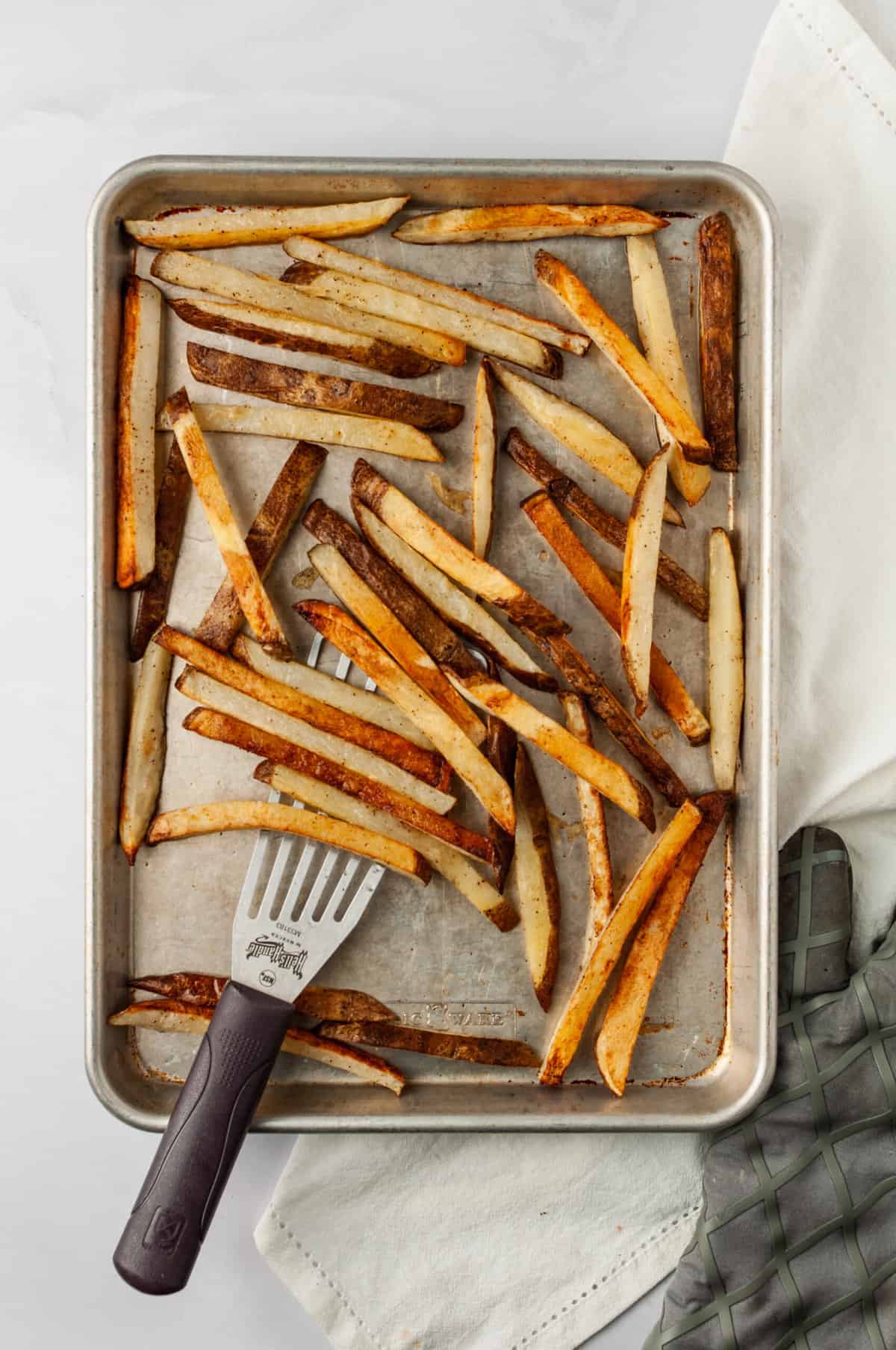 Overhead view of baked french fries on sheet pan