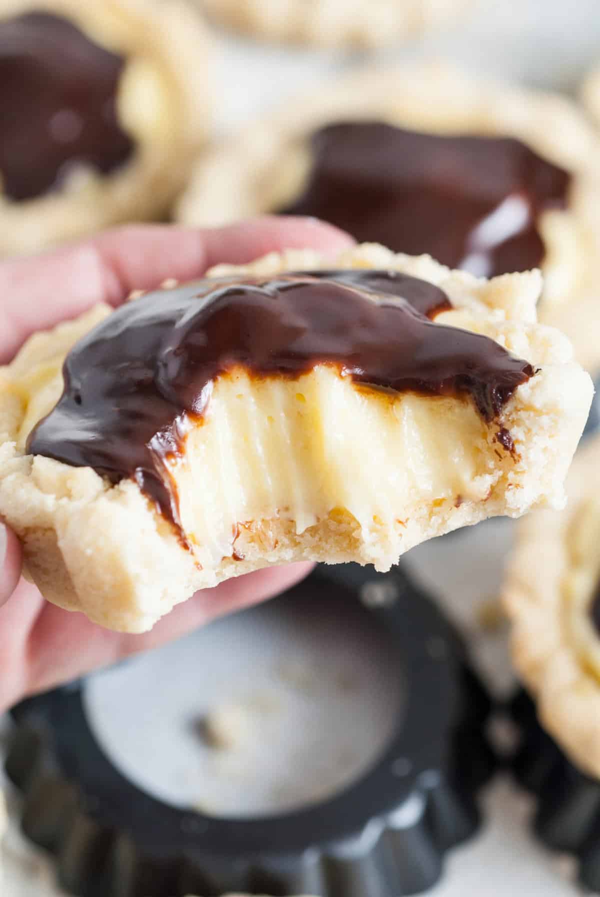 A Boston cream pie cookie with a bite taken out of it.