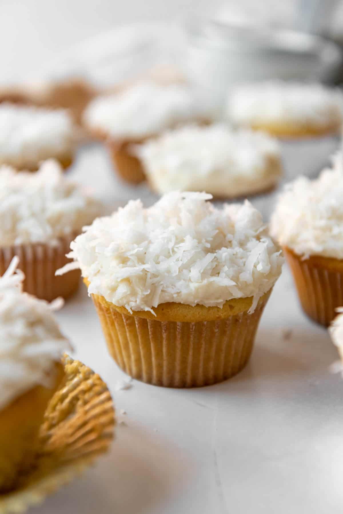 Homemade coconut cupcakes on a white surface.