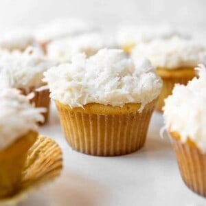 A homemade coconut cupcake with sweetened coconut on top.