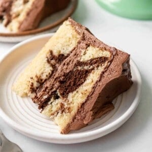A slice of homemade marble cake on a white plate.