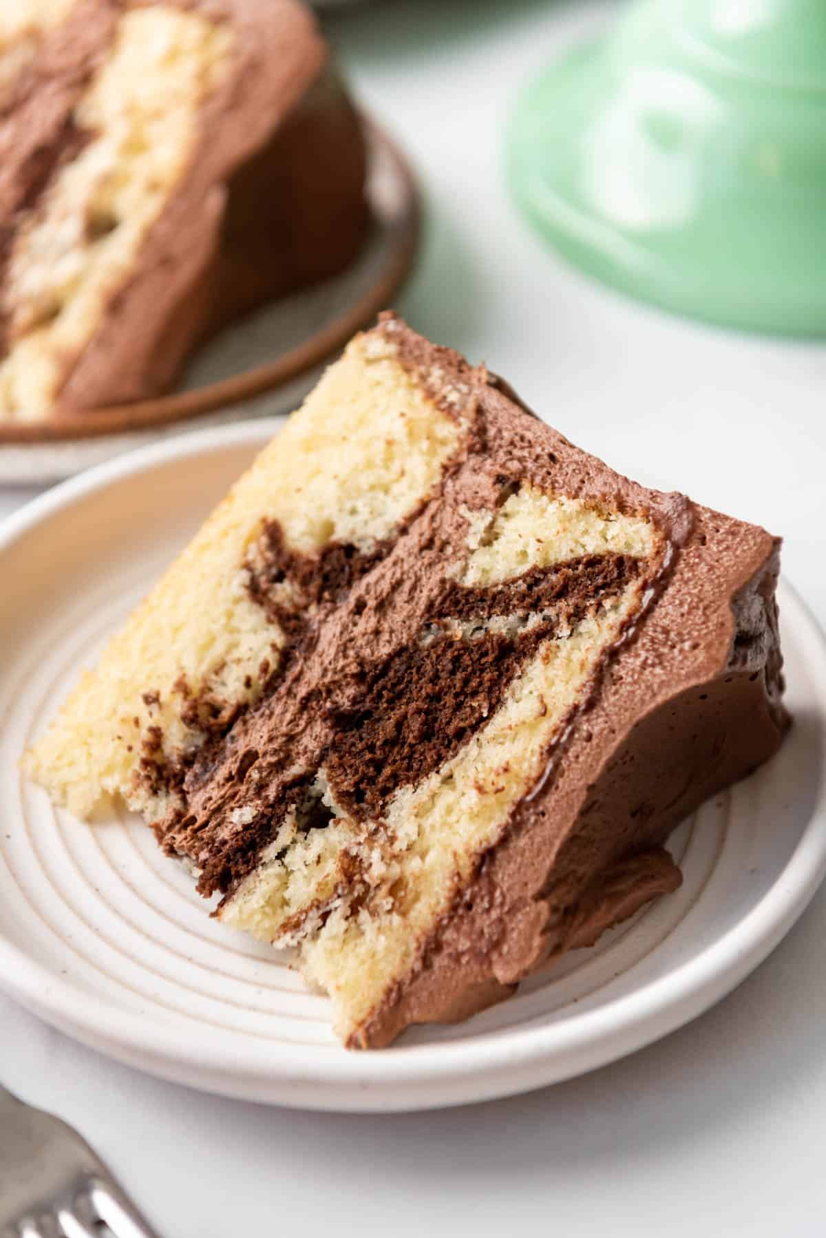 A slice of homemade marble cake on a white plate.
