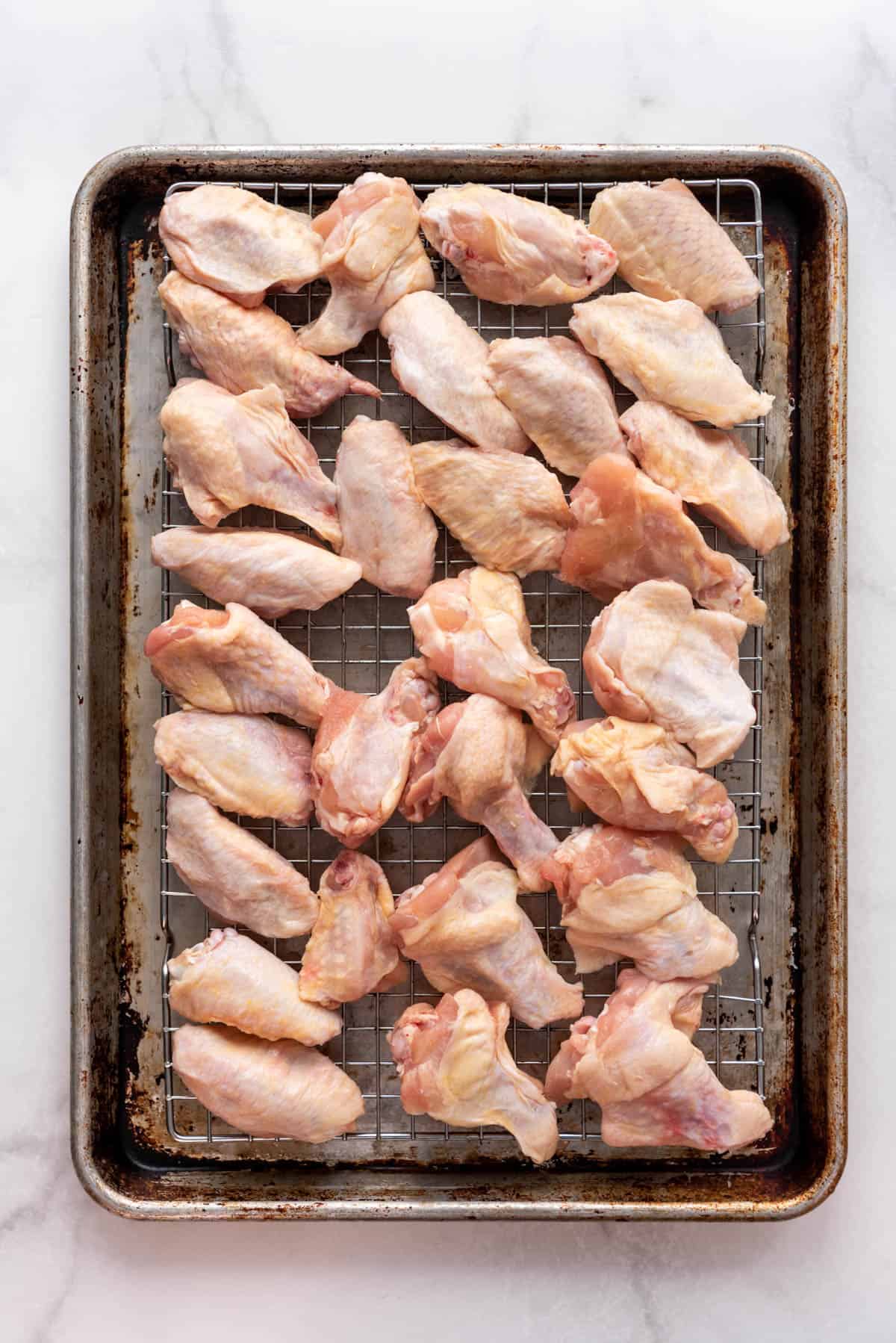 Chicken wings on a wire rack set over a baking sheet.