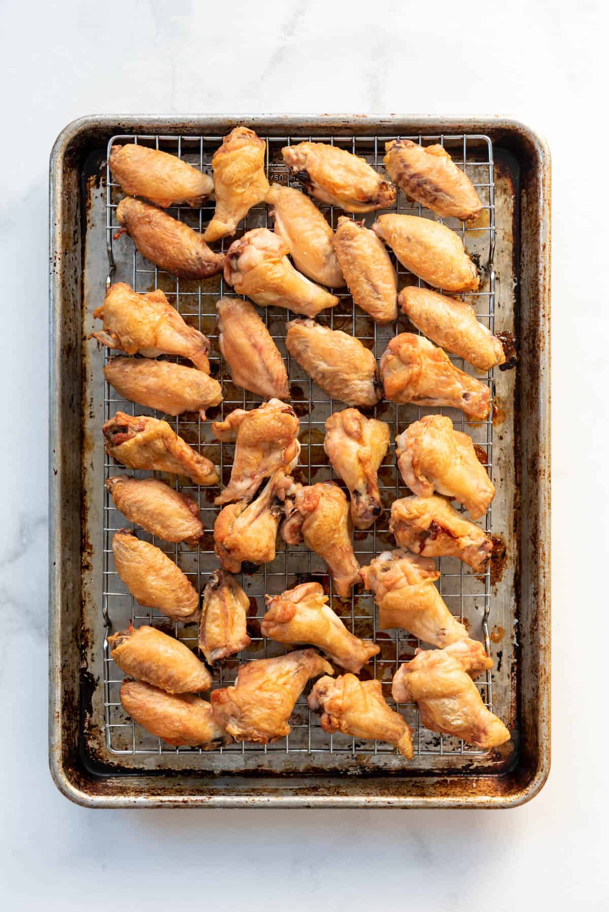 Crispy baked chicken wings on a wire rack set over a baking sheet.