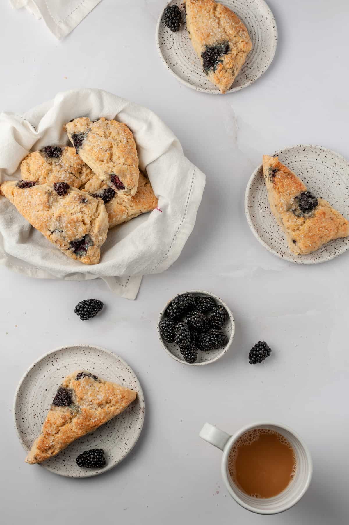 Overhead view of blackberry scones in basket and on plates