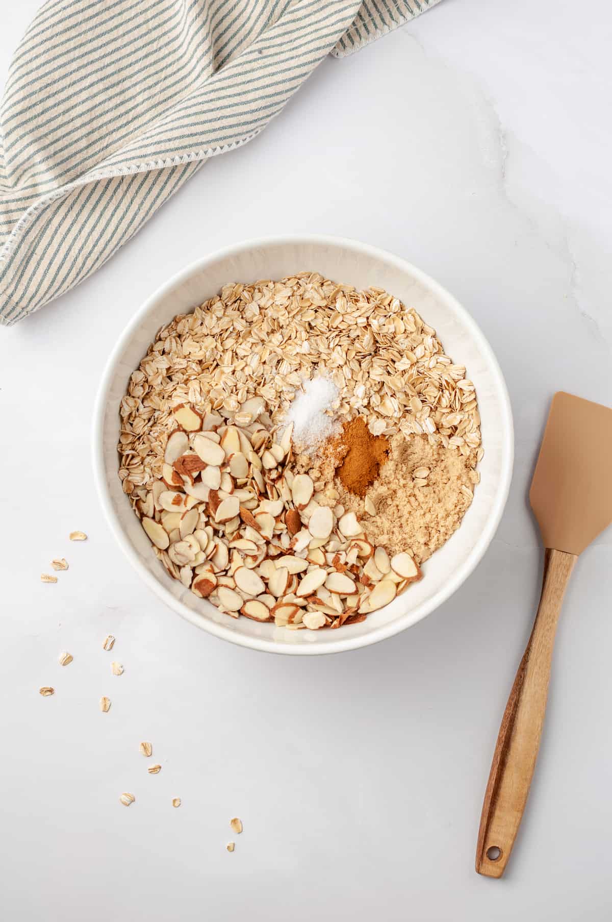 Overhead view of dry granola ingredients in mixing bowl
