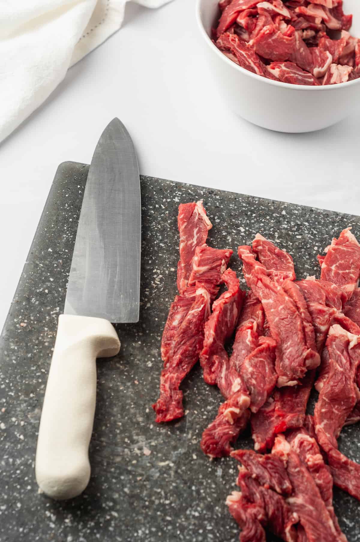 Sliced beef on cutting board with knife