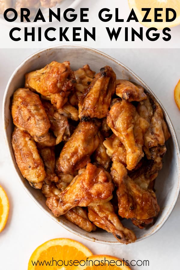 A large bowl of orange glazed chicken wings with text overlay.