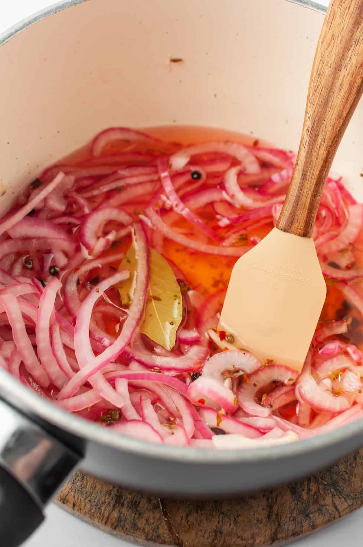 Escabeche ingredients in saucepan with spatula