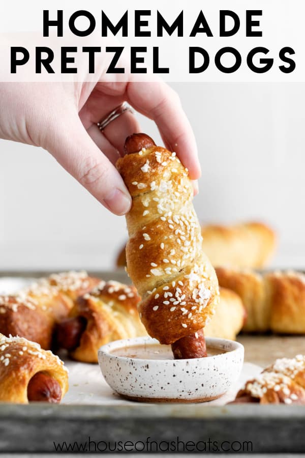 A hand dipping a pretzel dog into a sauce with more pretzel dogs around it and text overlay.