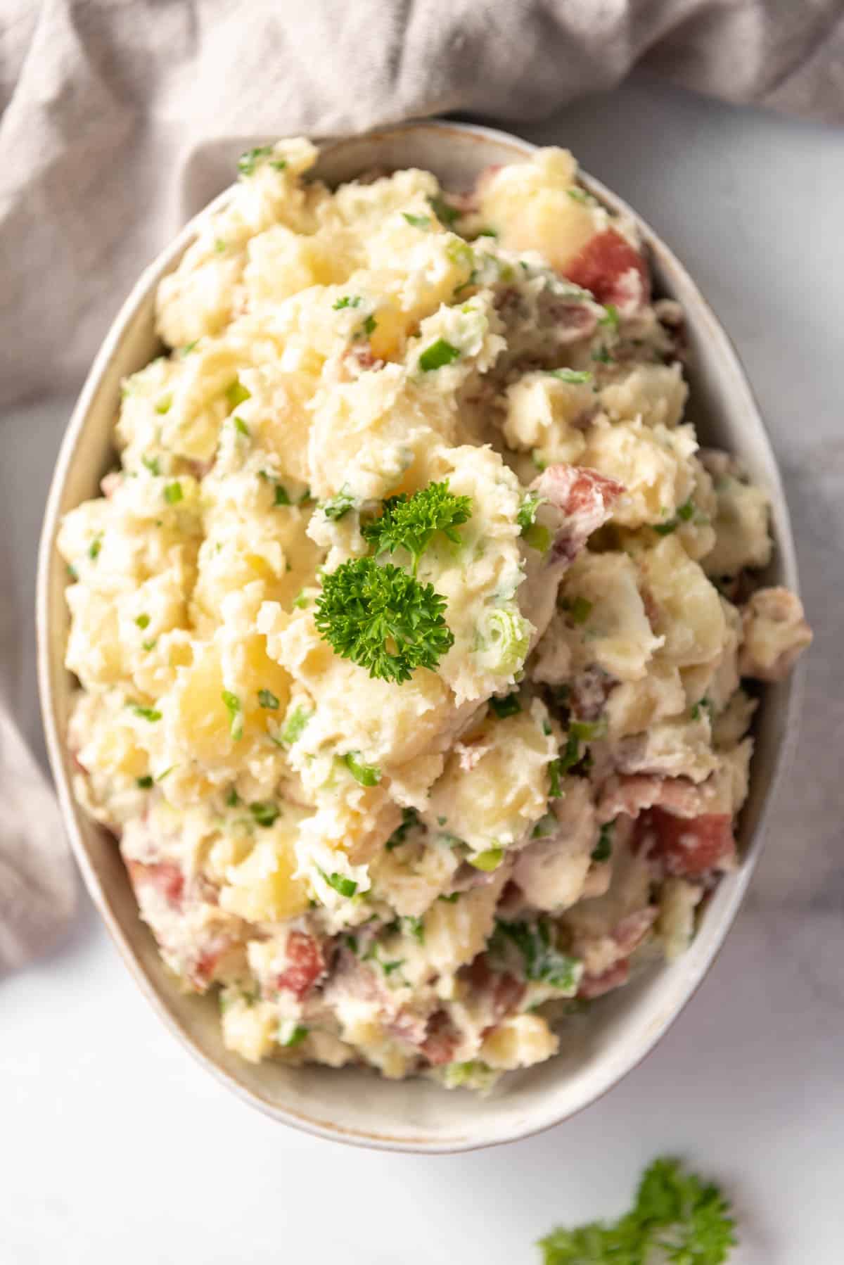 A serving bowl full of Greek potato salad.
