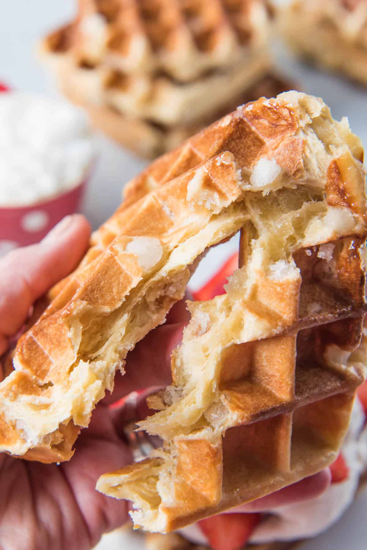 Breaking a waffle in half to show the soft inside.