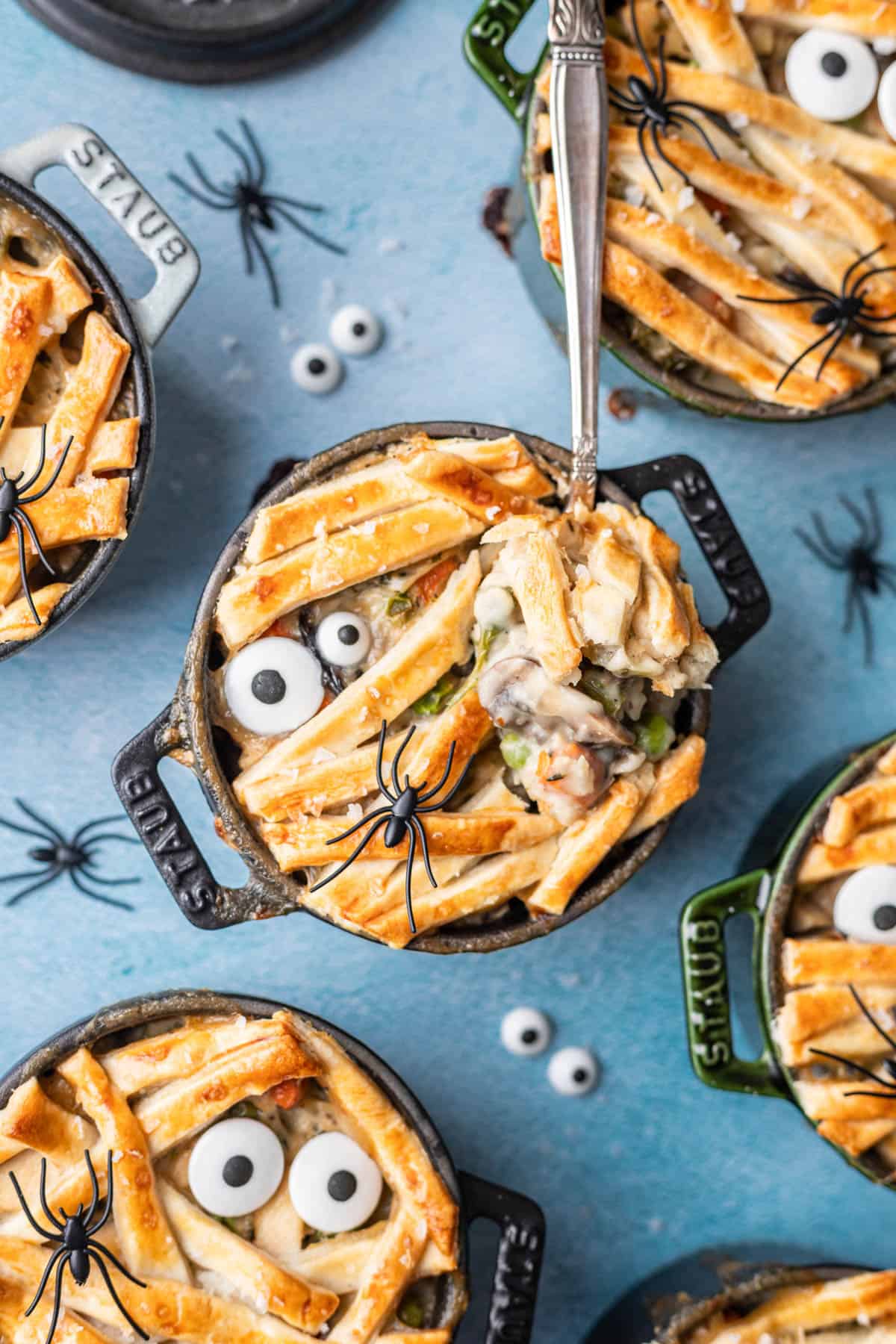 Mummy chicken pot pies with a spoon sticking in one of them lifting a bite of pot pie.