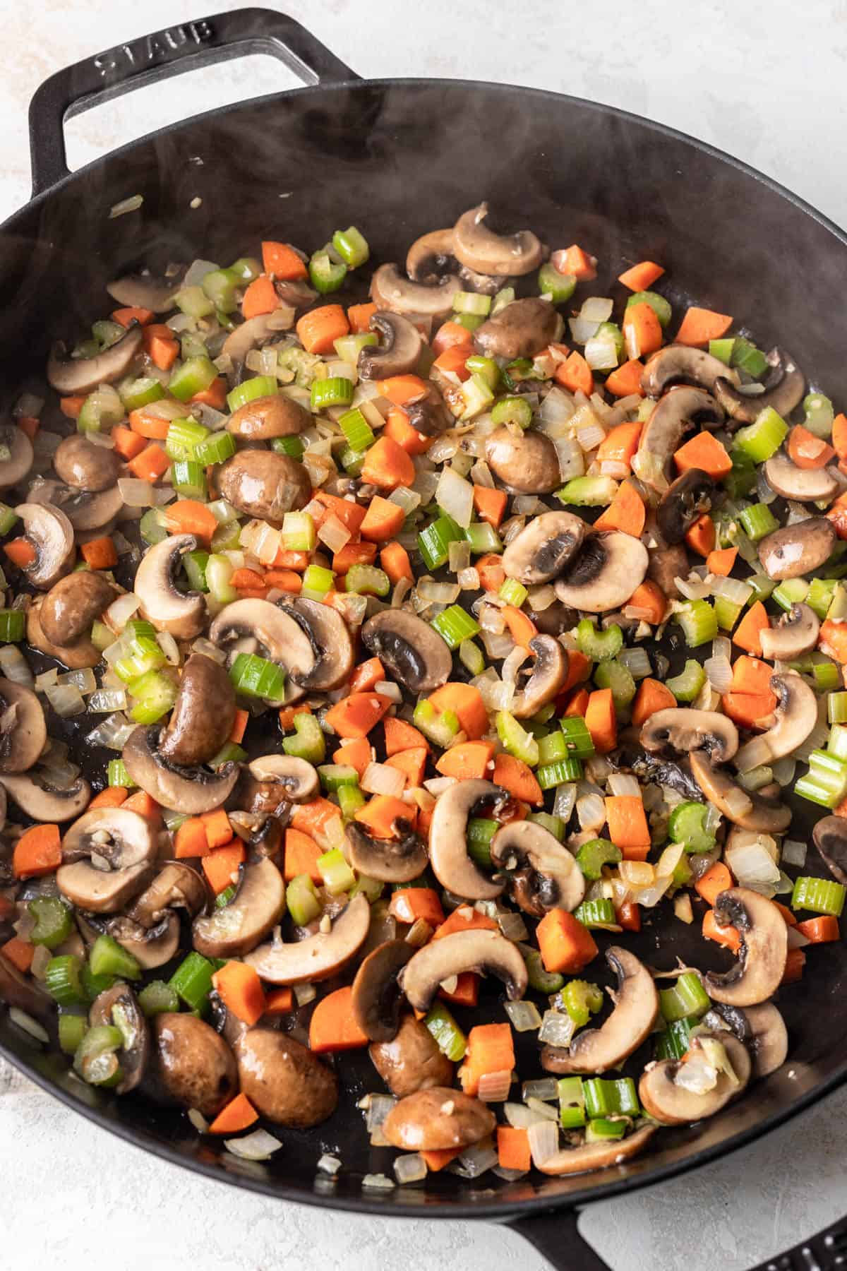 Sauteed vegetables and mushrooms in a large skillet.